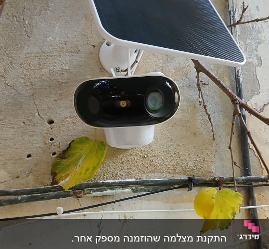 מצלמת אבטחה מותקנת על קיר עם פאנל סולארי